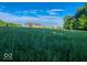 Beautiful two-story home sits on a lush green lot, under a brilliant blue sky with scattered clouds at 9083 W Koger Ln, Martinsville, IN 46151