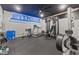 Home gym featuring a treadmill, weight machines, and brick accent wall at 9083 W Koger Ln, Martinsville, IN 46151