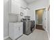 Laundry room features new washer and dryer, cabinetry, sink and tile floor at 9083 W Koger Ln, Martinsville, IN 46151