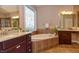Elegant bathroom with double vanity, soaking tub, and decorative window at 621 Greenford W Trl, Carmel, IN 46032