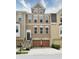 Brick three-story townhome with two-car garage and landscaped front yard at 621 Greenford W Trl, Carmel, IN 46032