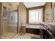 Elegant main bathroom featuring a glass-enclosed shower, a soaking tub, and a stylish vanity at 9955 Woodstock Way, Fishers, IN 46037