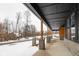 Covered porch extending along the side of the house, overlooking a snowy road at 2101 N Wolf Cv, Martinsville, IN 46151