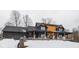 Modern farmhouse design with dark exterior and wood accents, set on a snowy lot at 2101 N Wolf Cv, Martinsville, IN 46151