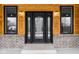 Black front door with glass accents and sidelights, set against a wood and brick exterior at 2101 N Wolf Cv, Martinsville, IN 46151