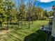 Scenic backyard with a manicured lawn, mature trees, and a patio area at 340 Beechwood Farm Ln, Indianapolis, IN 46260