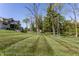 Expansive backyard with mature trees and lush lawn, leading to a modern home at 340 Beechwood Farm Ln, Indianapolis, IN 46260