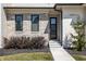 Inviting entryway with stone accents, a modern black door, and manicured landscaping at 340 Beechwood Farm Ln, Indianapolis, IN 46260