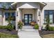 Inviting front porch with stone columns, stylish black doors, and charming outdoor seating area at 340 Beechwood Farm Ln, Indianapolis, IN 46260