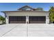 Three car garage featuring modern doors, exterior lighting, and a paved driveway at 340 Beechwood Farm Ln, Indianapolis, IN 46260