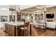 Open floor plan showcasing kitchen island with bar seating, fireplace and an adjoining living area at 340 Beechwood Farm Ln, Indianapolis, IN 46260