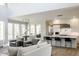 Bright, open-concept living room featuring large windows, modern furniture, and seamless flow into the kitchen and dining area at 340 Beechwood Farm Ln, Indianapolis, IN 46260