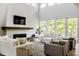 Bright living room with a modern fireplace, plush seating, neutral decor, and large windows at 340 Beechwood Farm Ln, Indianapolis, IN 46260