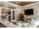 Cozy patio features stone walls, a TV, comfortable seating, and access to the home's interior at 340 Beechwood Farm Ln, Indianapolis, IN 46260
