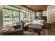 Cozy sunroom featuring stone walls, a view to the backyard, and a full outdoor kitchen at 340 Beechwood Farm Ln, Indianapolis, IN 46260
