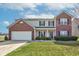 Charming two-story home with brick accents, a well-maintained lawn, and an attached two-car garage at 11851 Fawn Crest Dr, Indianapolis, IN 46235