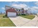 View of the home and driveway; two-story home with brick accents and a well-maintained lawn at 11851 Fawn Crest Dr, Indianapolis, IN 46235