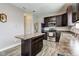 Open concept kitchen with stainless steel appliances, dark wood cabinets, and center island at 11851 Fawn Crest Dr, Indianapolis, IN 46235