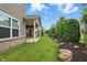 Landscaped backyard featuring a covered patio, green lawn, and varied plantings at 16311 Taconite Dr, Noblesville, IN 46060