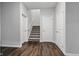 Hallway with wood-look flooring leading to carpeted stairs and closed doors at 16311 Taconite Dr, Noblesville, IN 46060