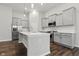 Modern kitchen boasts gray cabinets, center island, stainless appliances, and stylish pendant lighting at 16311 Taconite Dr, Noblesville, IN 46060