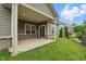 View of covered patio with brick accents, sliding glass door, and well-maintained lawn at 16311 Taconite Dr, Noblesville, IN 46060