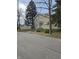 Two-story home with a stone facade, surrounded by mature trees, a fence, and street view at 927 E Southern Ave, Indianapolis, IN 46203