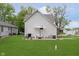 Backyard view with green lawn, patio furniture, grill, and the home's exterior at 47 Meadow Dr, New Palestine, IN 46163