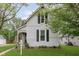Charming home with gray siding, black shutters, and a cozy front porch adorned with an American flag at 47 Meadow Dr, New Palestine, IN 46163