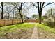 Spacious backyard featuring a wooden fence, a grassy lawn, and plenty of room for outdoor activities at 3634 N Kenwood Ave, Indianapolis, IN 46208