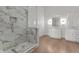 Modern bathroom featuring white marble tile shower, glass enclosure, and double vanity sinks at 1155 S Rangeline Rd # 501, Carmel, IN 46032