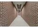 Long hallway featuring exposed brick walls and recessed lighting at 1155 S Rangeline Rd # 501, Carmel, IN 46032