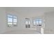 Spacious, unfinished living room featuring large windows and a sliding glass door to a balcony at 1155 S Rangeline Rd # 501, Carmel, IN 46032