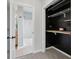 Open closet with black walls, shelves, and storage hooks, with a view to the bathroom at 2434 N Pennsylvania St, Indianapolis, IN 46205