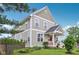 Attractive two-story home with manicured lawn, appealing landscaping, and inviting front porch with a bright red door at 2434 N Pennsylvania St, Indianapolis, IN 46205
