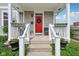 Inviting front porch with a bright red door adorned with a wreath, decorative railing, and charming flower boxes at 2434 N Pennsylvania St, Indianapolis, IN 46205