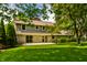 Exterior rear view of a two-story residence boasting a manicured lawn and stone facade at 725 Sugarbush Dr, Zionsville, IN 46077