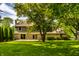 Expansive backyard with lush green grass, mature trees, and a stone and siding home exterior at 725 Sugarbush Dr, Zionsville, IN 46077