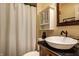 Bathroom featuring a pedestal sink, dark countertop, and white cabinet above the toilet at 725 Sugarbush Dr, Zionsville, IN 46077