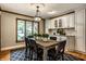 Bright dining room featuring a wood table, black chairs, a large window, and bright overhead lighting at 725 Sugarbush Dr, Zionsville, IN 46077
