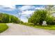 Entrance to Starkey Nature Park with a paved road surrounded by lush trees at 725 Sugarbush Dr, Zionsville, IN 46077