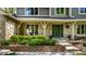 Inviting front porch with stone detailing, lush greenery, and charming seating area at 725 Sugarbush Dr, Zionsville, IN 46077