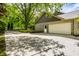 Attached two-car garage with a paved driveway surrounded by lush greenery at 725 Sugarbush Dr, Zionsville, IN 46077