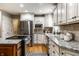 Bright kitchen featuring white cabinets, stainless steel appliances, granite counters, and hardwood floors at 725 Sugarbush Dr, Zionsville, IN 46077
