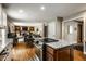 Open kitchen view into the living room with a hardwood floor, granite countertops, and stainless steel appliances at 725 Sugarbush Dr, Zionsville, IN 46077