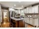 Bright kitchen featuring an island with an oven and cooktop, white cabinets, and stainless steel appliances at 725 Sugarbush Dr, Zionsville, IN 46077