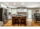 Bright open kitchen with an island and breakfast bar, white cabinets, and stainless steel appliances at 725 Sugarbush Dr, Zionsville, IN 46077