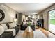 Open-concept living room with hardwood floors, modern decor, and a view of the kitchen at 725 Sugarbush Dr, Zionsville, IN 46077