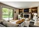 Sunlit living room with a stone fireplace, built-in shelving, and a sliding glass door at 725 Sugarbush Dr, Zionsville, IN 46077