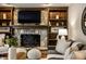 Comfortable living room with a stone fireplace, built-in shelving, and neutral accents at 725 Sugarbush Dr, Zionsville, IN 46077